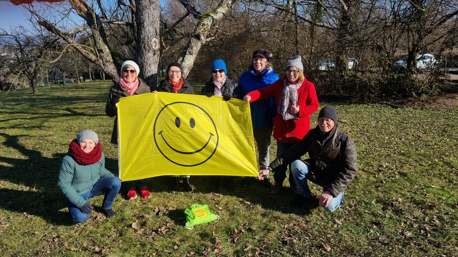 Lachscheune – Persönlichkeitsentwicklung/Entspannung – CollageFrau hält Banner mit Smiley-Gesicht